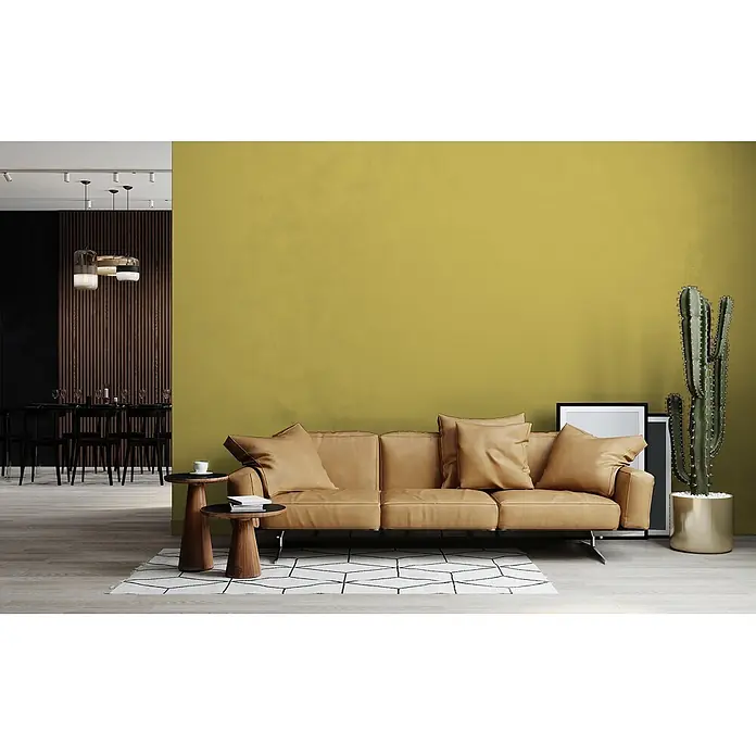 Livingwalls Wandfarbe Grün Gentle Lime DD125984 2,5l - Grün, Matt, 2,5 l - Ein braunes Ledersofa in einem Wohnzimmer, flankiert von Holznebentischen und einem großen Kaktus.