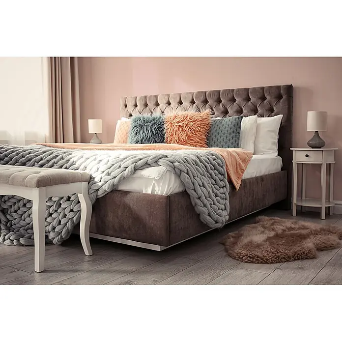 Livingwalls Wandfarbe Rosa Varied Red DD125819 2,5l - Rosa, Matt, 2,5 l - Gemütliches Schlafzimmer mit braunem, getuftetem Bett, einer groben grauen Strickdecke und farbigen Kissen.