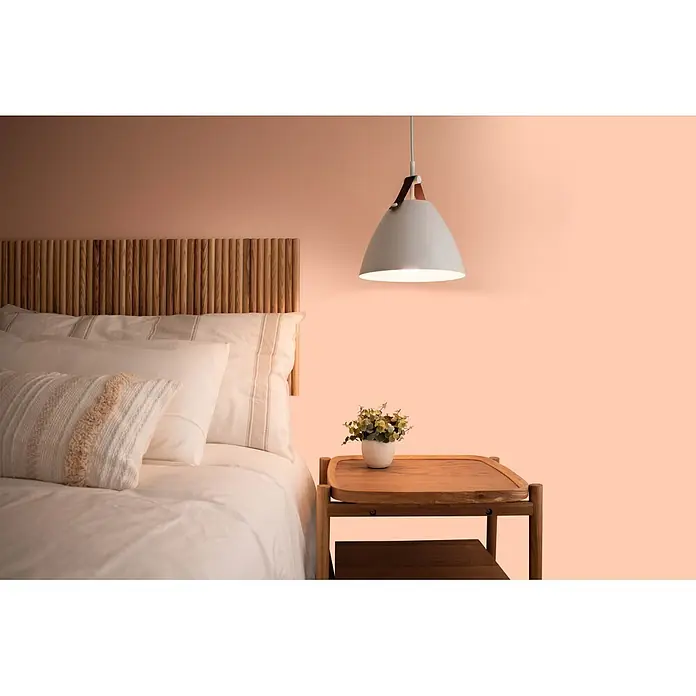 Livingwalls Wandfarbe Rosa Honeydew Melon 6022 2,5l - Matt, 2,5 l - Schlafzimmeransicht mit Bett, Lattenkopfteil aus Naturholz, weißer Bettwäsche, Holznachttisch mit Pflanze und Hängelampe.