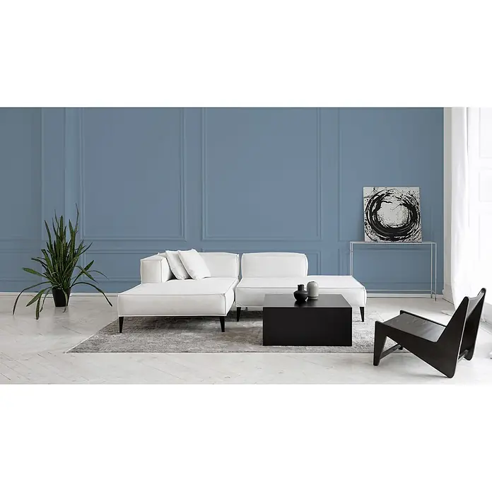 Livingwalls Wandfarbe Blau Ocean Blue DD125891 2,5l - Blau, Matt, 2,5 l - Geräumiges weißes Ecksofa, schwarzer quadratischer Couchtisch und schwarzer Loungesessel in einem modernen Wohnzimmer mit blauer Wand.