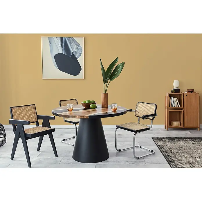 Livingwalls Wandfarbe Gelb Sunny Yellow DD126094 1l - Gelb, Matt, 1 l - Runder Esstisch mit schwarzem Fuß und Holzplatte, umgeben von Rattan- und schwarzen Stühlen in einem modernen Esszimmer.