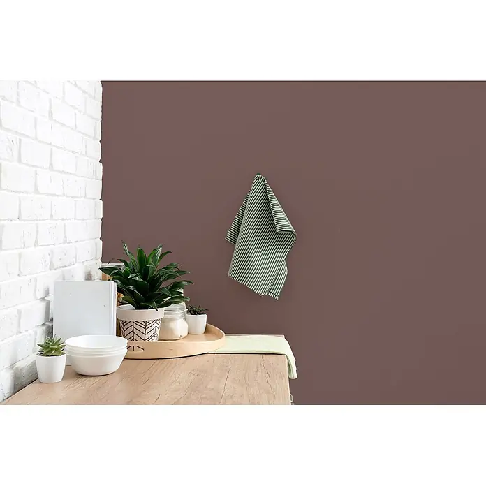Livingwalls Wandfarbe Braun Passion Fruit 5015 5l - Matt, 5 l - Grünes und weiß gestreiftes Küchentuch hängt an einer Wand, in einer gestylten Küchenecke mit Pflanzen und weißen Schalen auf einer Holztheke.