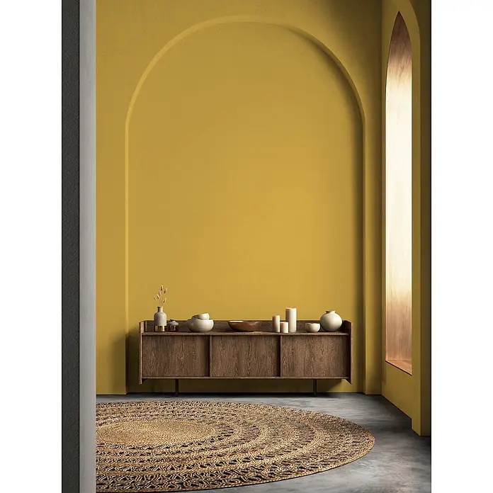 Livingwalls Wandfarbe Gelb Sunny Yellow DD126103 1l - Gelb, Matt, 1 l - Runder, geflochtener Teppich aus Naturfasern auf einem Betonboden in einem modernen Raum.