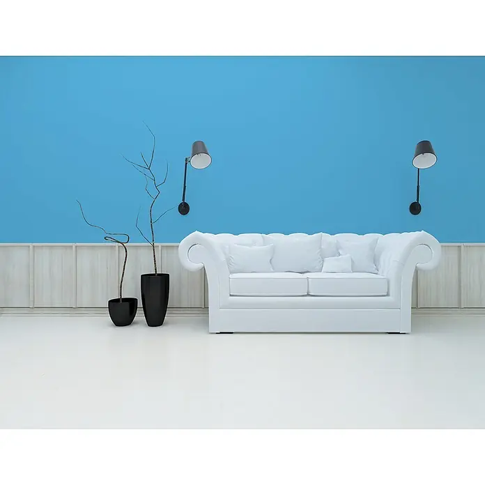 Livingwalls Wandfarbe Blau Ocean Blue DD125882 2,5l - Blau, Matt, 2,5 l - Weißes Chesterfield-Sofa mit Kissen, zwei Topfzweigen, blauer Akzentwand und zwei Lampen.