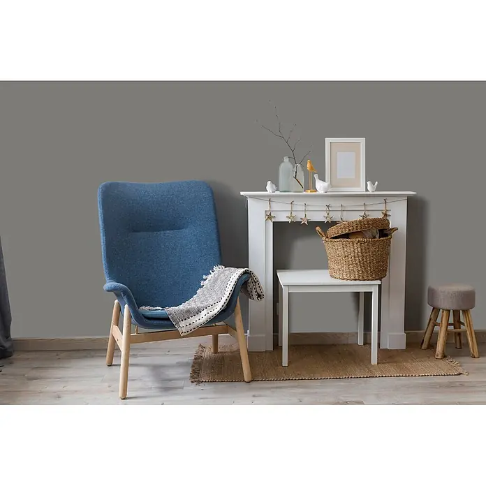 Livingwalls Wandfarbe Grau Poised Pepper 1013 2,5l - Matt, 2,5 l - Blauer Stoff-Sessel mit hellen Holzbeinen und Dekodecke.