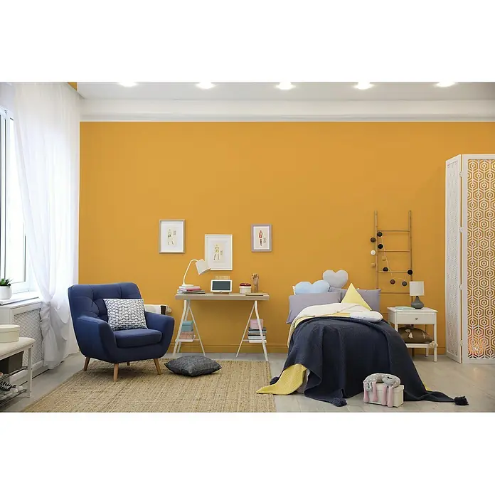 Livingwalls Wandfarbe Gelb Sunny Yellow DD126112 1l - Gelb, Matt, 1 l - Gemütliches, modernes Schlafzimmer mit leuchtend gelben Wänden, blauem Sessel, Bett und Schreibtisch.