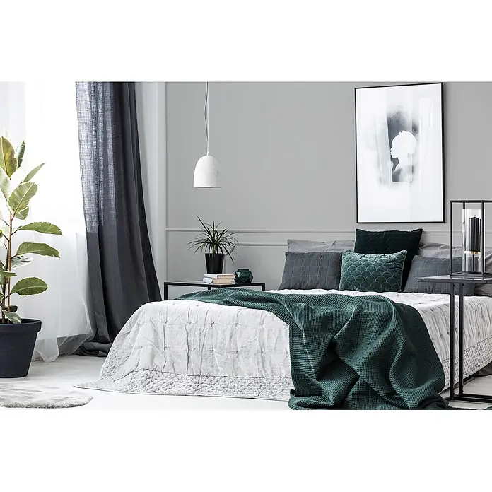 Livingwalls Wandfarbe Grau Cool Grey DD125737 1l - Grau, Matt, 1 l - Grüne Waffelstrickdecke auf einem Bett mit grauer Bettwäsche und Kissen.