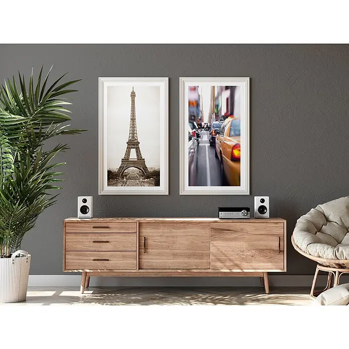 Livingwalls Wandfarbe Grau Chic Chia 1006 2,5l - Matt, 2,5 l - Medienkonsole aus Naturholz mit drei Schubladen und einer Seitentür, die Lautsprecher und einen Audio-Receiver trägt.