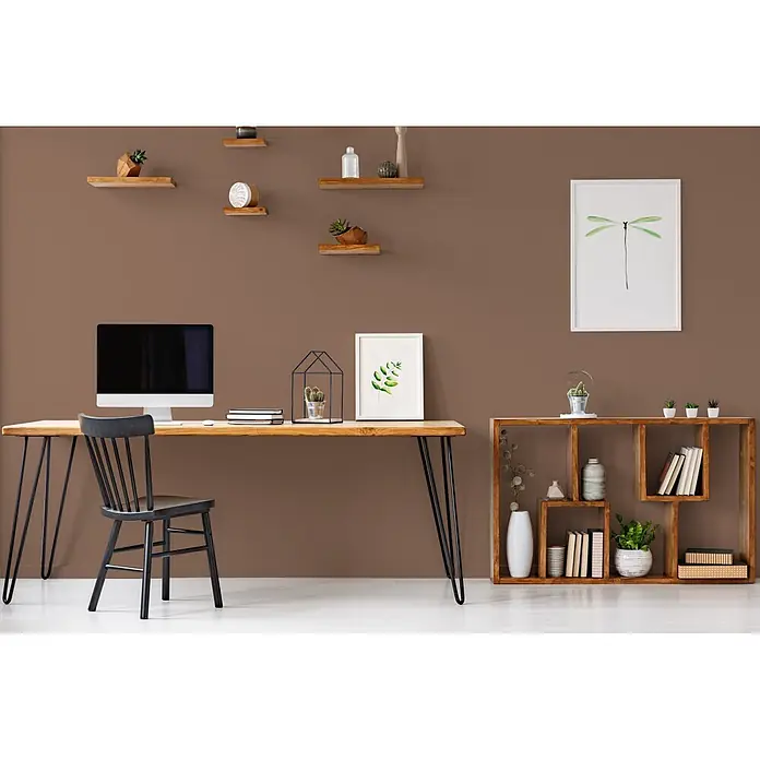 Livingwalls Wandfarbe Braun Rosy Rosine 6013 5l - Matt, 5 l - Ein modernes Home-Office mit Holzschreibtisch, schwarzem Stuhl, Computer und Regaleinheiten an einer braunen Wand mit schwebenden Regalen und Bildern.