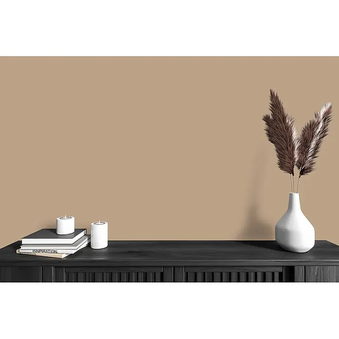 Livingwalls Wandfarbe Braun Friendly Fennel 6005 5l - Matt, 5 l - Dunkle Holzkonsole dekoriert mit Büchern, weißen Kerzen und einer Vase mit trockenem Gras vor beigefarbener Wand.