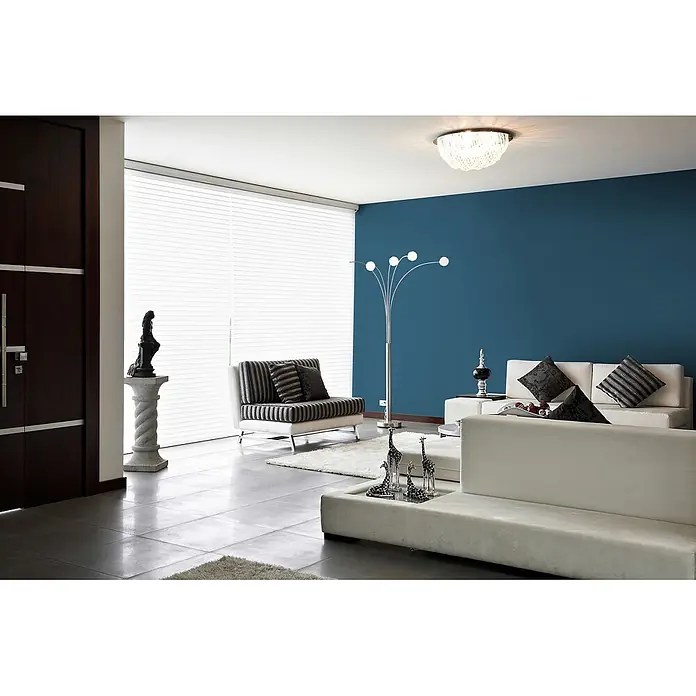 Livingwalls Wandfarbe Blau Ocean Blue DD125889 5l - Blau, Matt, 5 l - Ein modernes Wohnzimmer mit weißen Sofas, einem gestreiften Sessel, einer dunkelblauen Wand und weißen Jalousien.