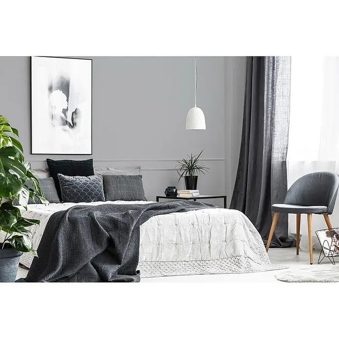 Livingwalls Wandfarbe Grau Cool Grey DD125740 1l - Grau, Matt, 1 l - Ein modernes graues Schlafzimmer mit einem großen Bett, grauen Kissen und einer strukturierten dunkelgrauen Tagesdecke.