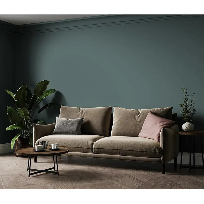 Livingwalls Wandfarbe Grün Soft Green DD125934 5l - Grün, Matt, 5 l - Ein bequemes, strukturiertes hellbraunes Sofa mit Kissen, Couchtisch und Pflanzen in einer einladenden Wohnzimmerszene.