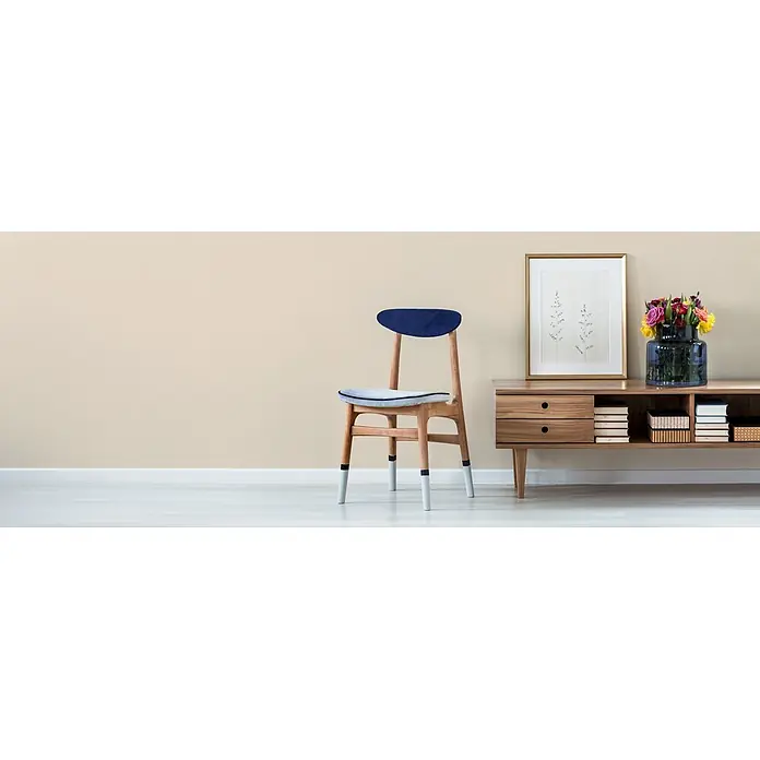 Livingwalls Wandfarbe Beige Piña Colada 5001 2,5l - Matt, 2,5 l - Minimalistischer Raum mit einem blau gepolsterten Holzstuhl und einem Holzschrank mit Dekoartikeln.