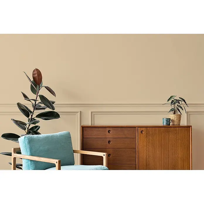 Livingwalls Wandfarbe Beige Asthetic Artichoke 6003 5l - Matt, 5 l - Wohnzimmer im Mid-Century-Stil mit hellblauem Sessel, Holzkommode und Zimmerpflanzen vor beigefarbener Wand.