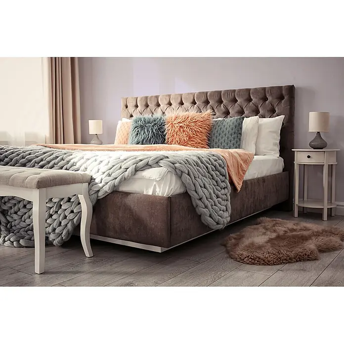 Livingwalls Wandfarbe Violett Simple Mauve DD125783 2,5l - Violett, Matt, 2,5 l - Ein plüschiges Kingsize-Bett mit getuftetem dunkelbraunem Kopfteil, bedeckt mit gemütlichen Pfirsich- und grob gestrickten grauen Decken und Zierkissen.