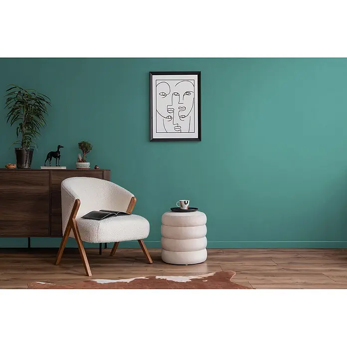 Livingwalls Wandfarbe Blau Emerald Green DD125939 2,5l - Blau, Matt, 2,5 l - Weißer Bouclé-Sessel mit Holzbeinen neben einem cremefarbenen Ottoman und Holzschrank.