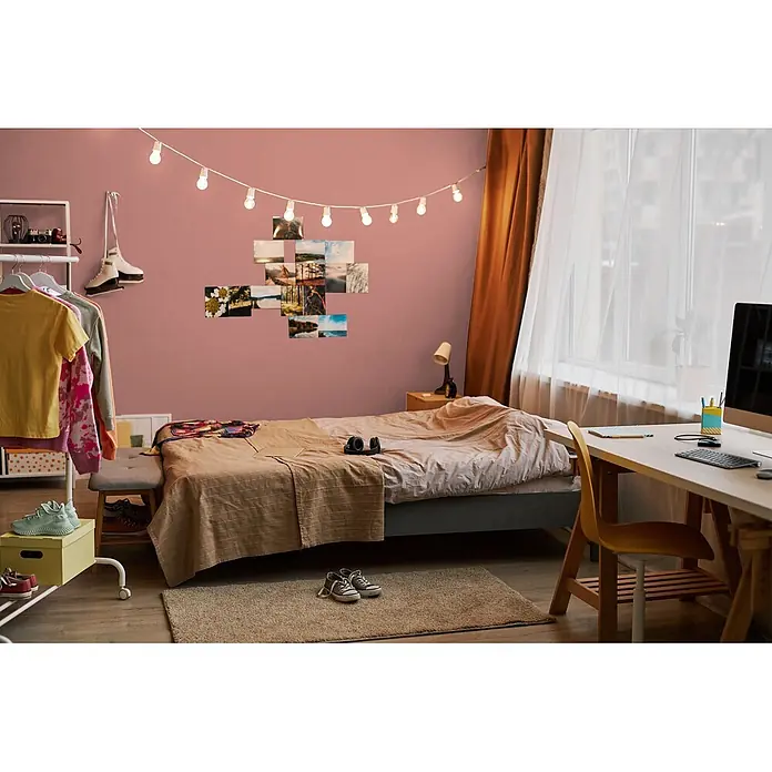 Livingwalls Wandfarbe Rot Varied Red DD125827 1l - Rot, Matt, 1 l - Ein farbenfrohes, persönlich eingerichtetes Schlafzimmer mit Bett, Schreibtisch, Kleiderstange, Lichterkette, Fotos und Schlittschuhen.