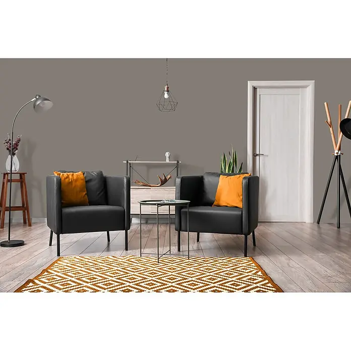 Livingwalls Wandfarbe Taupe Earl Grey Tea 1021 2,5l - Matt, 2,5 l - Zwei schwarze Sessel mit orangefarbenen Kissen und einem orange-weißen geometrischen Teppich in einem modernen Wohnzimmer.