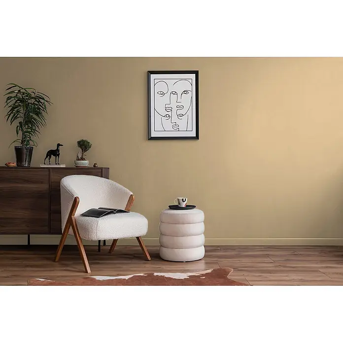 Livingwalls Wandfarbe Beige Smooth Saffron DD126126 5l - Beige, Matt, 5 l - Gemütliches Wohnzimmer mit weißem Bouclé-Sessel, hellbeigem Hocker, dunklem Holzschrank und abstrakter Kunst; stilvoller Entspannungsbereich.