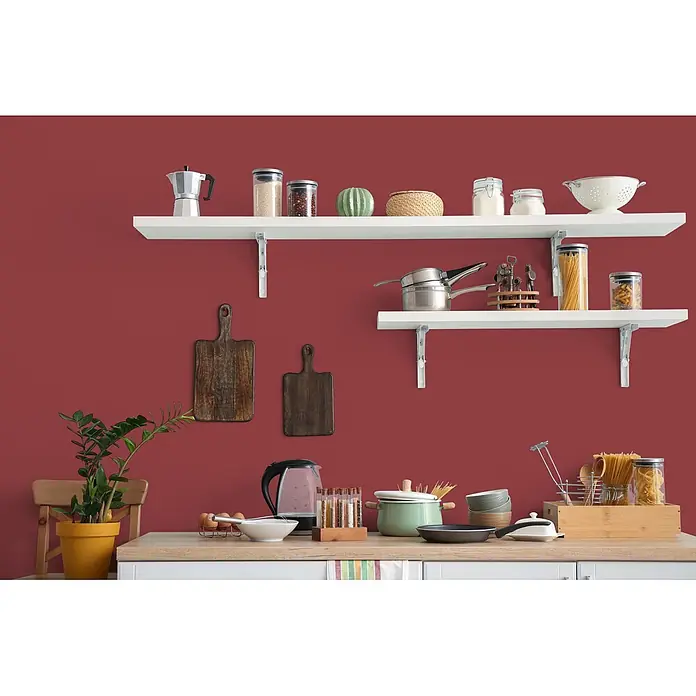 Livingwalls Wandfarbe Rot Perky Pomegranate 7006 2,5l - Rot, Matt, 2,5 l - Funktionale Küche mit roten Wänden, weißen Regalen mit Küchenutensilien und einer Arbeitsplatte mit Kochwerkzeugen.