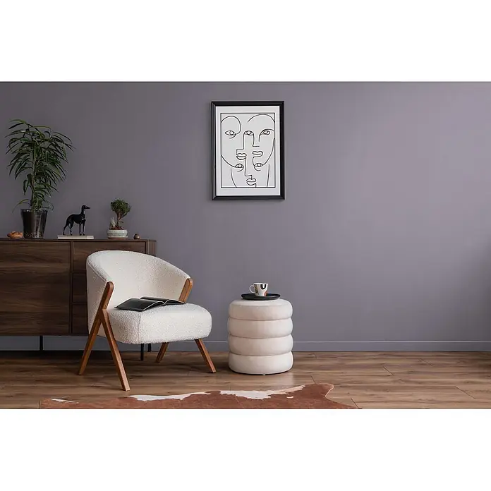 Livingwalls Wandfarbe Violett Simple Mauve DD125776 1l - Violett, Matt, 1 l - Weißer Bouclé-Sessel mit Holzbeinen und gestapeltem beigen Ottoman in einem modernen Wohnzimmer.