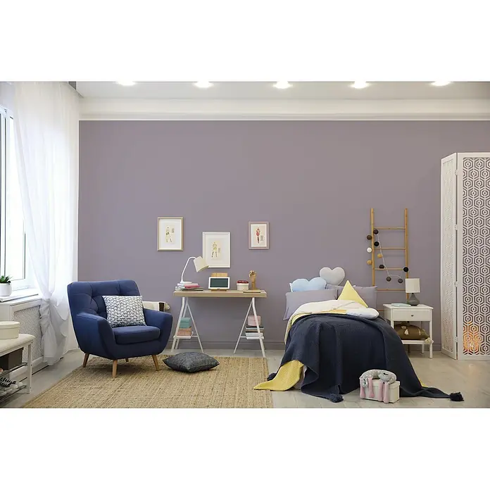 Livingwalls Wandfarbe Violett Simple Mauve DD125776 1l - Violett, Matt, 1 l - Gemütliches Schlafzimmer mit Bett, Schreibtisch und blauem Sessel auf Teppich, vor einer lavendelfarbenen Wand.