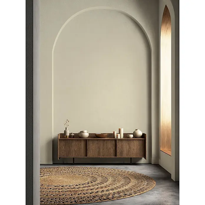 Livingwalls Wandfarbe Grün Gentle Lime DD125976 5l - Grün, Matt, 5 l - Runder Teppich aus Naturfasern mit aufwendigem Flechtmuster auf dunklem Boden in minimalistischem Raum.
