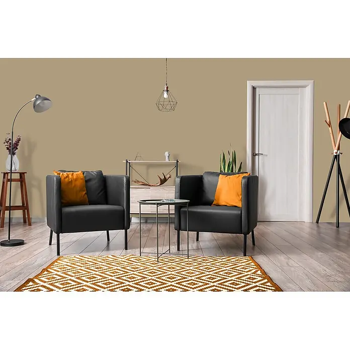 Livingwalls Wandfarbe Grün Green Lentil 6001 5l - Matt, 5 l - Zwei schwarze Sessel mit orangefarbenen Kissen und einem orangefarbenen Teppich mit geometrischem Muster in einem modernen Wohnzimmer.