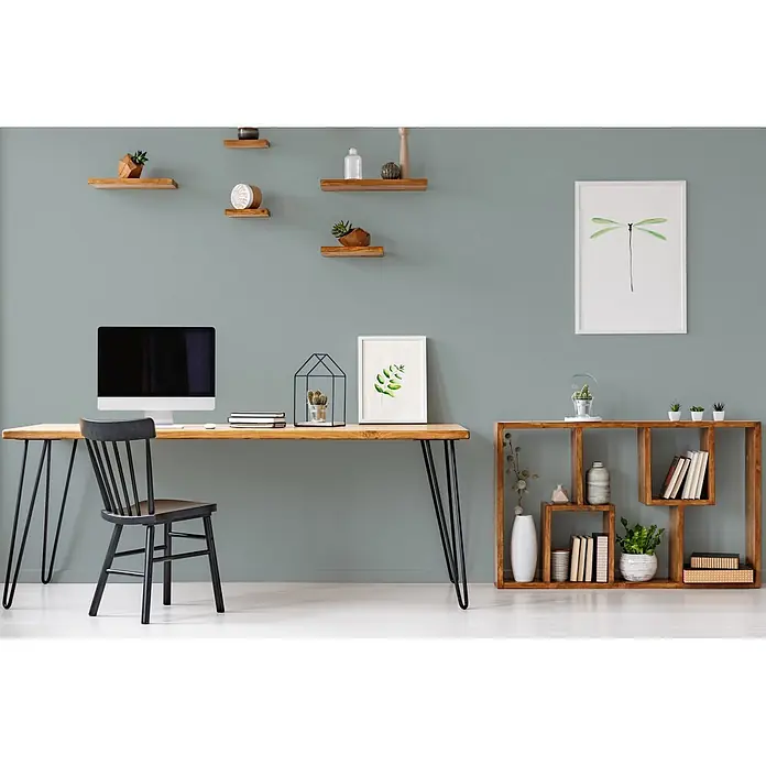 Livingwalls Wandfarbe Grün Unique Eucalyptus 3009 5l - Matt, 5 l - Ein Heimbüro mit hellem Holzschreibtisch mit schwarzen Haarnadelbeinen, einem schwarzen Holzstuhl und einem modularen Holzregal.