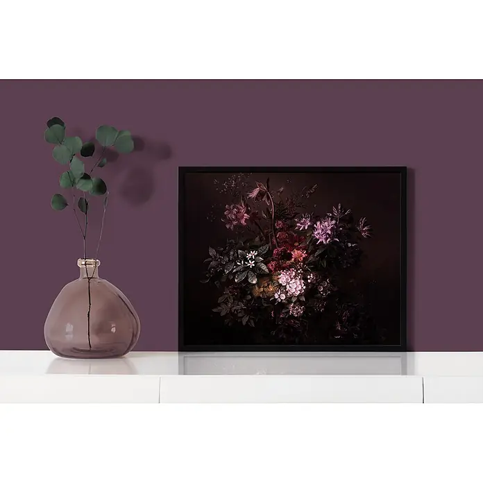 Livingwalls Wandfarbe Violett Beady Beetroot 2007 2,5l - Matt, 2,5 l - Dunkler Blumendruck in schwarzem Rahmen auf einem weißen Regal neben einer lila Vase mit Eukalyptuszweigen.