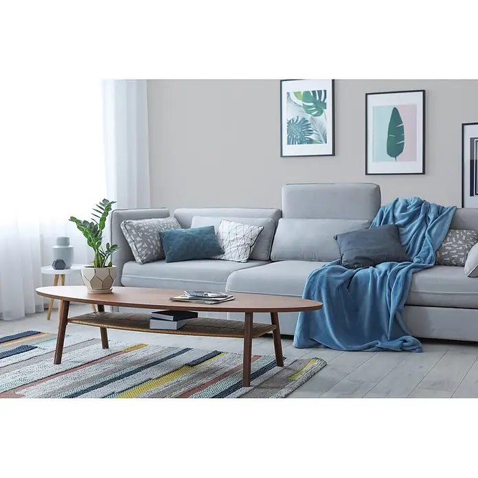 Livingwalls Wandfarbe Grau Sprat Fish 1009 5l - Matt, 5 l - Helles graues Ecksofa in einem modernen Wohnzimmer, mit Zierkissen und einer blauen Decke versehen, bietet bequemen Sitzkomfort.