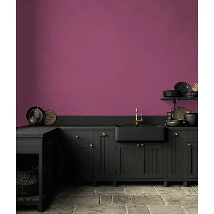 Livingwalls Wandfarbe Pink Lovely Rose DD125797 1l - Pink, Matt, 1 l - Schwarze Küchenschränke und Spüle mit Goldarmatur vor einer magentafarbenen Wand und Steinboden.