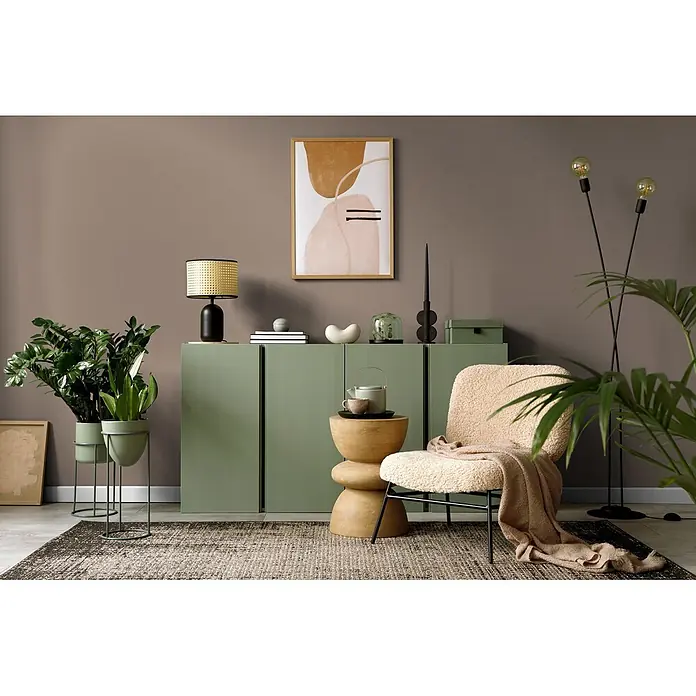 Livingwalls Wandfarbe Braun Calm Taupe DD126010 1l - Braun, Matt, 1 l - Moderner salbeigrüner Aufbewahrungsschrank in einem Wohnzimmer, ergänzt durch einen beigefarbenen Sessel und Pflanzen.
