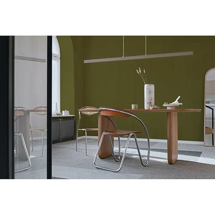 Livingwalls Wandfarbe Grün Gentle Lime DD126001 1l - Grün, Matt, 1 l - Moderner Holzesstisch mit einzigartigem Fuß und verchromten Stühlen mit braunen Ledersitzen in einem Esszimmer.