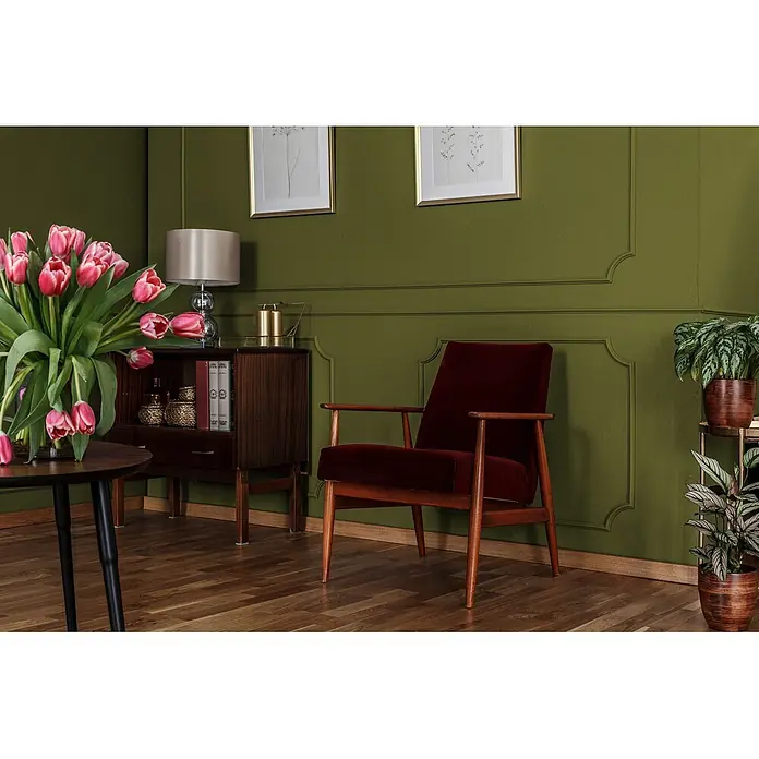 Livingwalls Wandfarbe Grün Gentle Lime DD126001 1l - Grün, Matt, 1 l - Roter Samtsessel mit Holzrahmen, in einem stilvollen Wohnzimmer neben einem Holzschrank und Pflanzen.