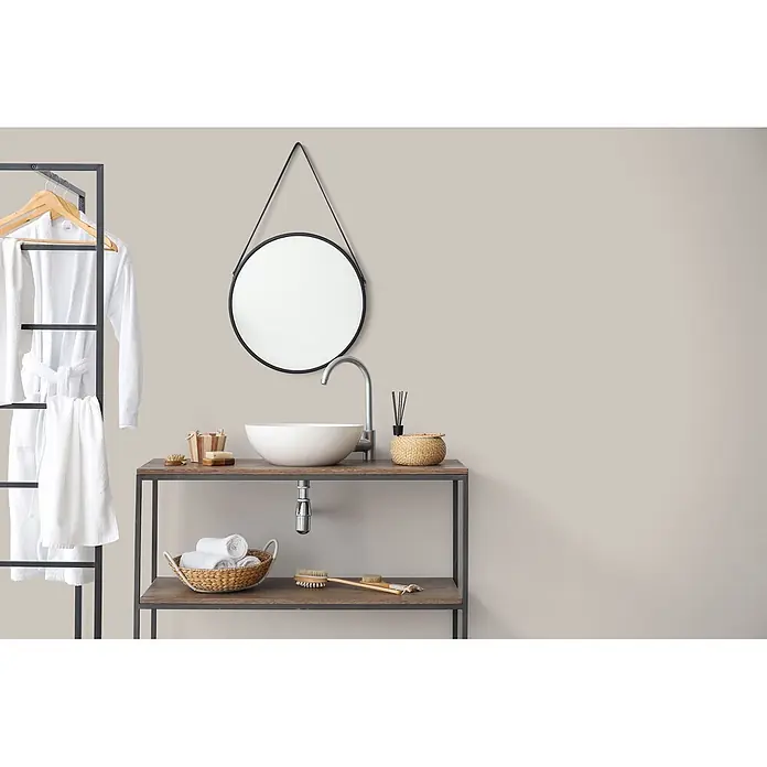 Livingwalls Wandfarbe Taupe Oyster Mushroom 1017 2,5l - Matt, 2,5 l - Modernes Badezimmer mit rundem Spiegel, weißem Aufsatzwaschbecken auf Holzwaschtisch und schwarzem Metallgestell mit Bademänteln.