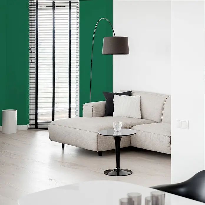Livingwalls Wandfarbe Grün Sage Green DD125958 5l - Grün, Matt, 5 l - Ein modernes Wohnzimmer mit beigem Ecksofa und Kissen, einer eleganten schwarzen Stehlampe und einem minimalistischen schwarzen Beistelltisch.
