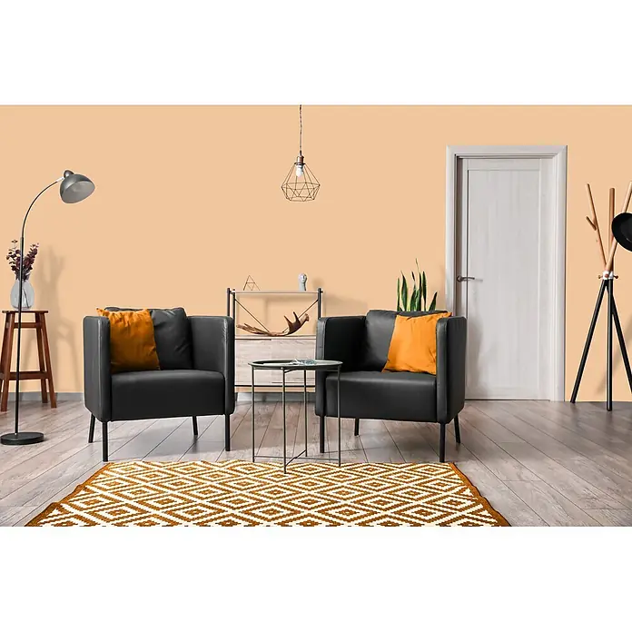 Livingwalls Wandfarbe Beige Pithy Pancake 5009 2,5l - Matt, 2,5 l - Zwei schwarze Sessel mit orangefarbenen Kissen und einem gemusterten orange-weißen Teppich in einem modernen Wohnzimmer.