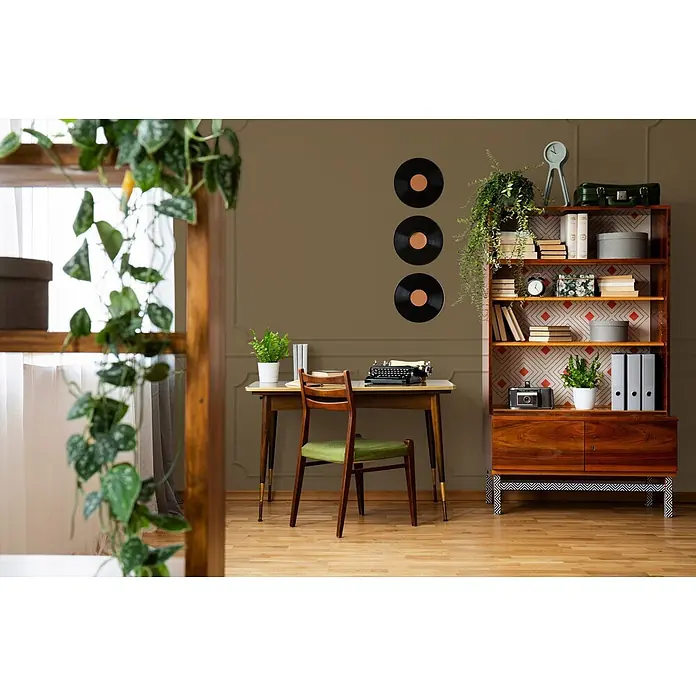 Livingwalls Wandfarbe Braun Tasty Truffle 6014 2,5l - Matt, 2,5 l - Ein gemütliches Home Office mit Holzschreibtisch, Vintage-Schreibmaschine und Bücherregal voller Bücher und Dekorationen. Schallplatten schmücken die Wand.