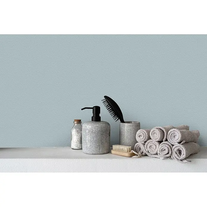 Livingwalls Wandfarbe Grün Detailed Duckegg 3001 2,5l - Matt, 2,5 l - Badezimmer-Essentials: grauer Seifenspender, Badesalze, Haarbürste, Körperbürste und gerollte hellgraue Handtücher auf einem Regal.