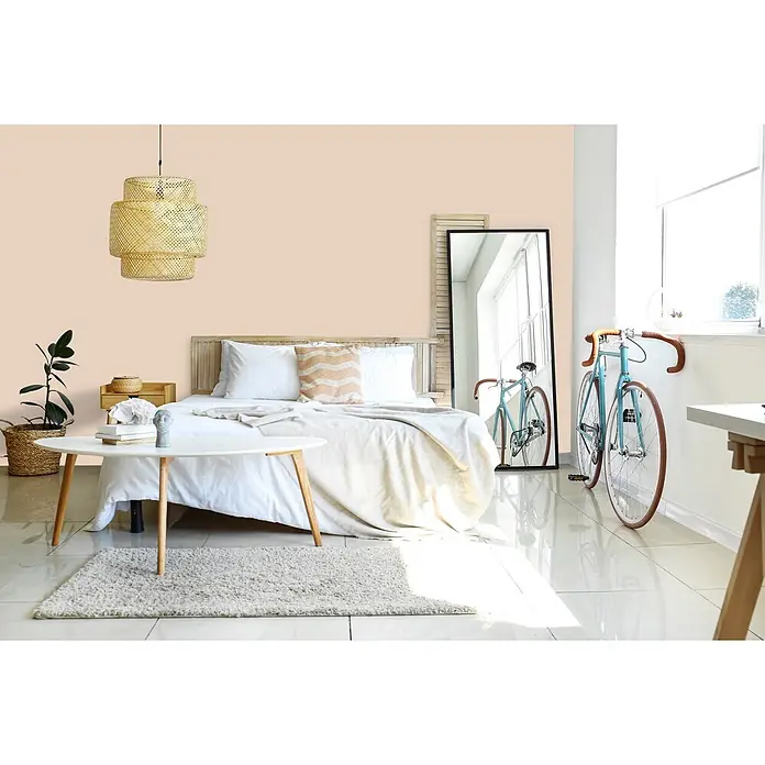 Livingwalls Wandfarbe Beige Chalky Chickpeas 6020 5l - Matt, 5 l - Hellpfirsichfarbene Wand in einem Schlafzimmer.
