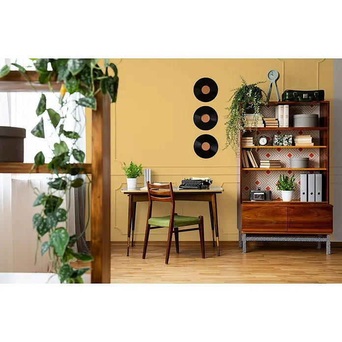 Livingwalls Wandfarbe Gelb Playful Pineapple 5005 5l - Matt, 5 l - Retro-Büro mit Holzschreibtisch, grünem Stuhl, gemustertem Regal und Schallplatten an gelber Wand.