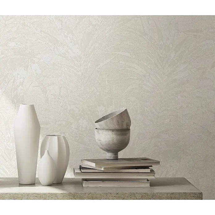 Livingwalls Vliestapete Floral, weiß - 10.050 x 530 mm - Helle Tapete mit dezentem, strukturiertem Palmenblattmuster an einer Wand, präsentiert mit Deko-Vasen und Büchern.