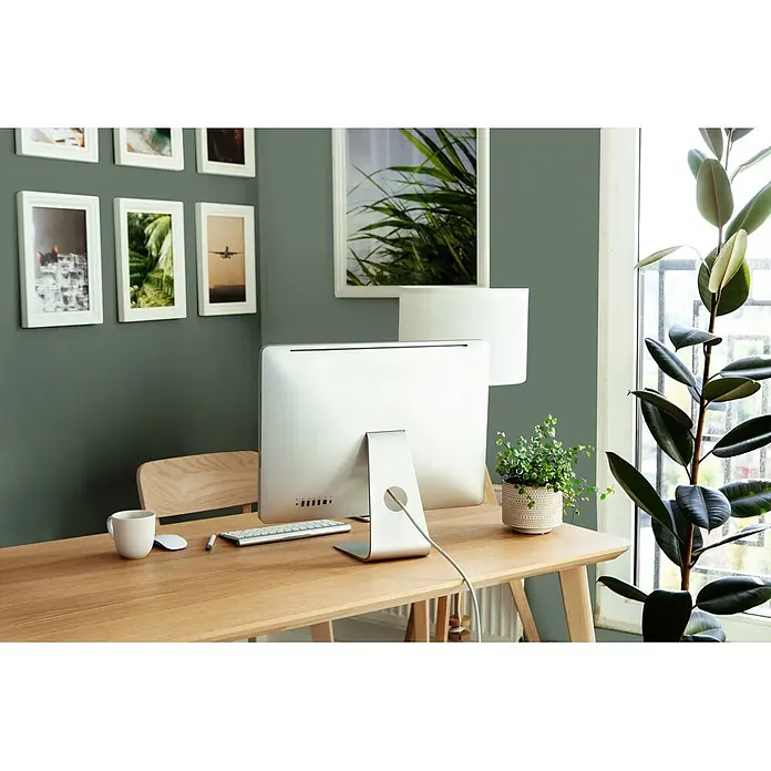 Livingwalls Wandfarbe Grün Ritzy Rosemary 4005 2,5l - Matt, 2,5 l - Ein heller Holzschreibtisch mit Computer, Tastatur, Maus und Kaffeetasse. Eine kleine Topfpflanze steht ebenfalls auf dem Schreibtisch.