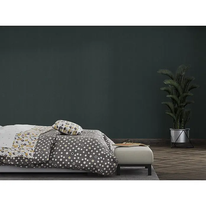 Livingwalls Vliestapete Uni, schwarz - 10.050 x 530 mm - Ein Bett mit grauem Bettbezug mit weißen und gelben Tupfen, einer gelb-lila gemusterten Decke und einem geometrisch gemusterten Kissen.