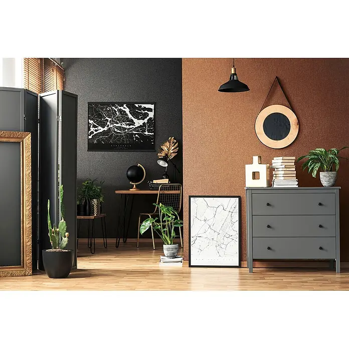 Livingwalls Vliestapete Uni, schwarz - 10.050 x 530 mm - Moderner Arbeitsbereich mit dunkler Wand, Schreibtisch, Goldstuhl und Karte, kontrastiert von einer braunen Wand mit grauer Kommode, Pflanzen und Holzspiegel.