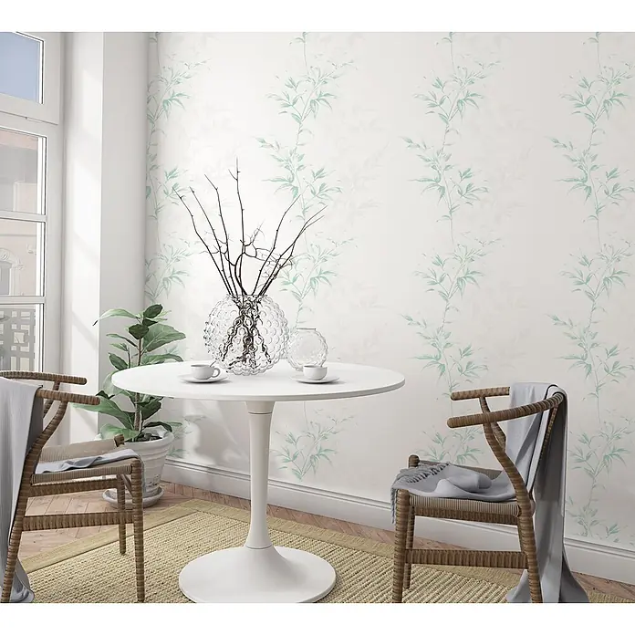Livingwalls Vliestapete Floral, weiß, grün - grün - Tapete mit grünem Bambusmuster in einem hellen Raum mit kleinem Tisch und Stühlen.