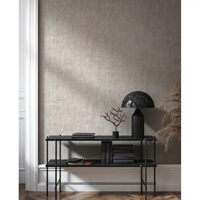 Livingwalls Vliestapete Betonoptik, hellbeige - 10.050 x 530 mm - Schwarze Marmor-Konsole mit Metallgestell, dekoriert mit Büchern und Lampe in einem Raum.