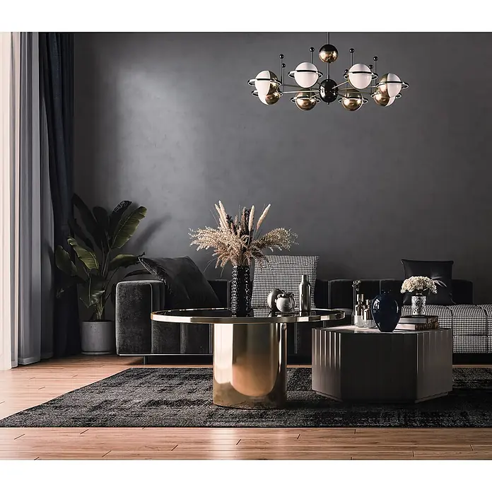 Livingwalls Vliestapete Putzoptik, anthrazit - 10.050 x 530 mm - Modernes Wohnzimmer mit einem eleganten runden Couchtisch in Gold und einem dunklen sechseckigen Tisch vor einem Sofa.